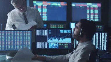 Takım of borsacılarla göstermek perde ile karanlık bir ofiste bir tartışma sahip.