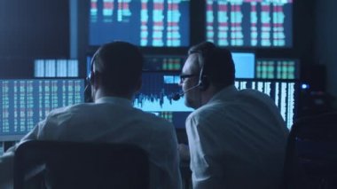 Takım of borsacılarla göstermek perde ile karanlık bir ofiste bir tartışma sahip.