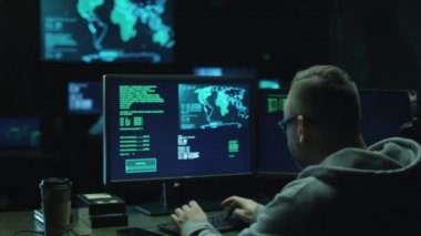 Haritalar ve veriler üzerinde göstermek perde bir karanlık office odada bulunan bir bilgisayarda bir Hood erkek hacker çalışır.