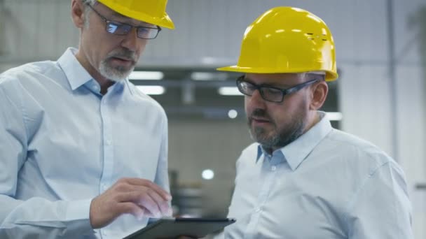 Dva zaměstnanci jednají o práci s počítačem tablet na logistické centrum skladu. — Stock video