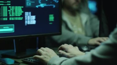 Yakın çekim görüntülerini haritalar ile bir bilgisayarlarda davlumbaz çalışır ve veri göstermek perde bir karanlık office odada üzerinde iki bilgisayar korsanları.