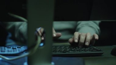 Yazma ve Oda karanlık ofis ile göstermek perde haritaları ve veri alanındaki bir bilgisayarda çalışan erkek çalışan konsantre.