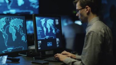BT profesyonel programcı bardaklarda göstermek perde ile dolu siber güvenlik Merkezi'ndeki bilgisayar üzerinde çalışıyor.
