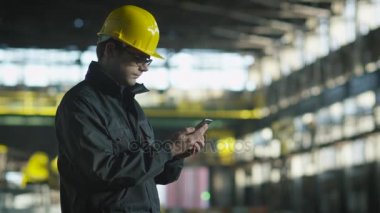 Teknisyen sabit hat telefon sanayi ortamında kullanarak.