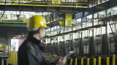 Teknisyen sanayi ortamında çalışma sert şapkalı. Tablet elinde tutan.