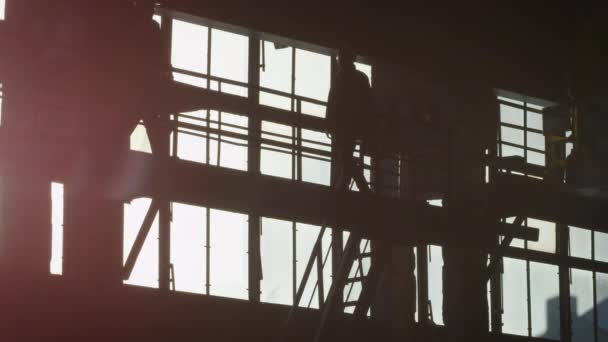 Silhouette de deux travailleurs sur chantier . — Video