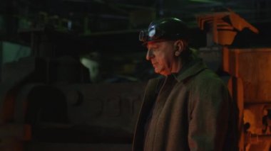 Ağır sanayi işçisi döküm kalite kontrol yapıyor. Zorlu endüstriyel ortamlar. Geniş çekim.