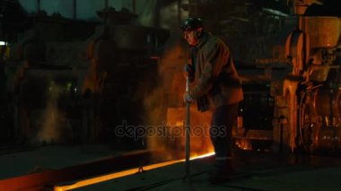 Ağır sanayi işçisi döküm kalite kontrol yapıyor. Zorlu endüstriyel ortamlar. Geniş çekim.