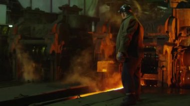 Sert döküm içinde ağır sanayi işçisi. Zorlu endüstriyel ortamlar. Geniş çekim.