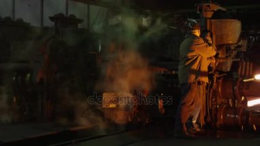 Ağır sanayi işçisi döküm kalite kontrol yapıyor. Zorlu endüstriyel ortamlar. Geniş çekim.