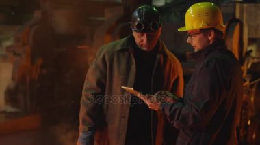 İki işçi konuşma ve Tablet PC'yi döküm içinde kullanma hakkına sahiptir. Zorlu endüstriyel ortamlar.