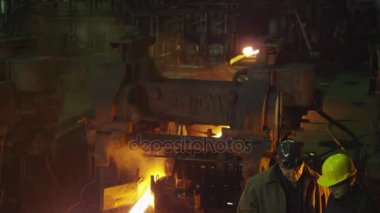 Mühendis ve işçi döküm içinde görüşme. Zorlu endüstriyel ortamlar.