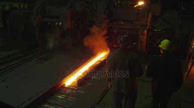 Mühendis ve işçi yürüyüş ve döküm içinde görüşme. Zorlu endüstriyel ortamlar.