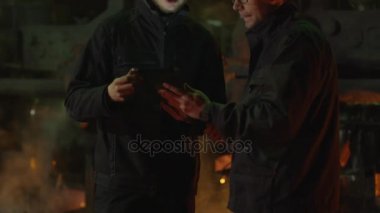 Konuşma ve Tablet Pc kullanarak döküm içinde iki işçi var