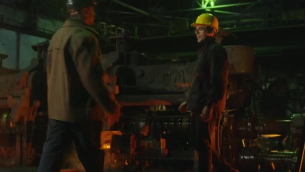 Ingenieur und Arbeiter unterhalten sich in der Gießerei. raues industrielles Umfeld. — Stockvideo