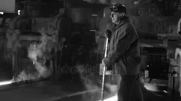 重工業の労働者は、鋳造に取り組んでいます。ワイド ショット。黒と白。粗い産業環境. — ストック動画