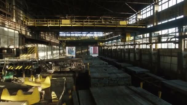 Воздушная съемка внутри большого промышленного здания с движущимися электромагнитными кранами . — стоковое видео