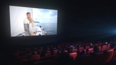 Bir grup insan bir sinema sinema salonunda eleme bir drama filmi izliyor.