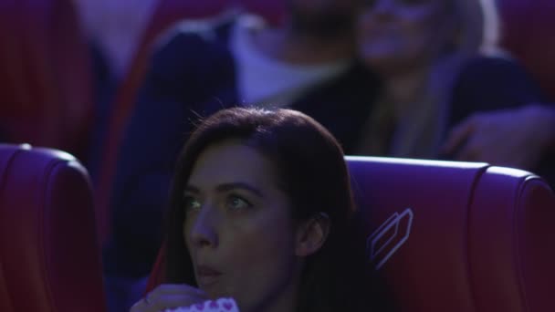 Junges glückliches romantisches Paar schaut sich eine Filmvorführung in einem Kino an. — Stockvideo