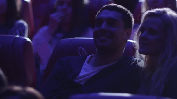 Joven pareja romántica se besa mientras ve una proyección de cine en un cine . — Vídeos de Stock