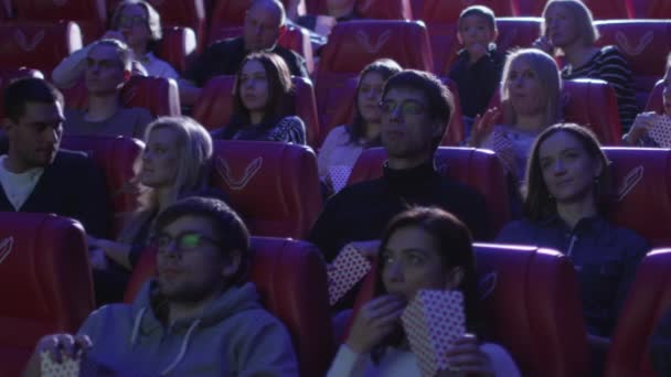 Uitgang van de man uit zijn zetel terwijl mensen een film screening in een bioscoop cinema kijken. — Stockvideo