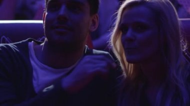 Genç mutlu Romantik Çift bir sinema sinema salonunda ellerini tutarken bir film gösterimi izliyor.