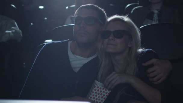 Casal abraçar uns aos outros enquanto se divertem assistindo a exibição de filmes 5d no cinema . — Vídeo de Stock