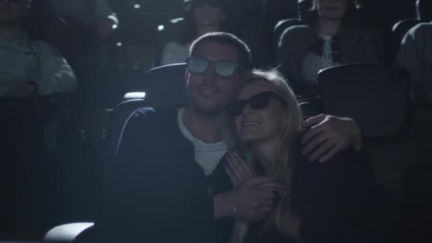 Coppia abbracciarsi mentre si diverte a guardare la proiezione di film 5d nel cinema . — Video Stock