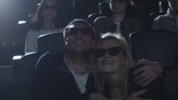 Casal abraçar uns aos outros enquanto se divertem assistindo a exibição de filmes 5d no cinema . — Vídeo de Stock