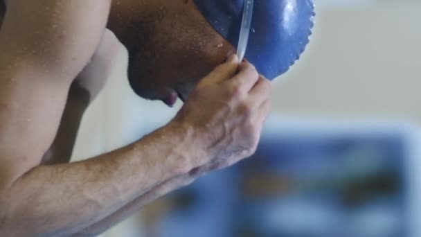 Nuotatore maschio concentrato professionale in occhiali da sole sul blocco di partenza prima di saltare in acqua . — Video Stock