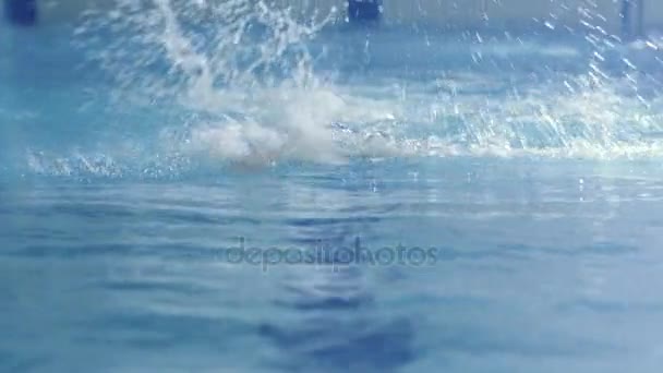 Disparo desde el frente del nadador masculino profesional que realiza el rastreo frontal durante el entrenamiento en la piscina — Vídeos de Stock