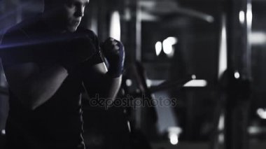 Profesyonel erkek boxer eğitim yumruklar ve koyu spor salonunda başladı.