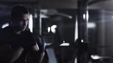 Profesyonel erkek boxer eğitim yumruklar ve koyu spor salonunda başladı.