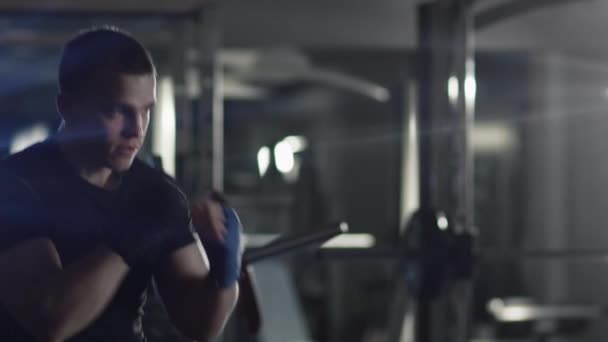 Boxeador masculino profesional está entrenando golpes y patadas en el gimnasio . — Vídeos de Stock