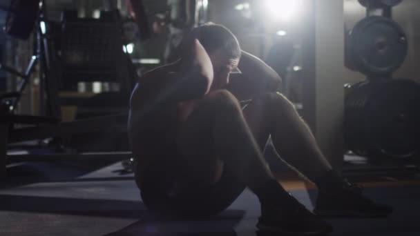 Bonito homem desportivo ajuste faz exercícios abdominais no ginásio . — Vídeo de Stock