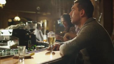 İnsanların iyi vakit geçiriyor musun iken bir barda bira ile tek başına oturan bir adam Timelapse görüntüleri.
