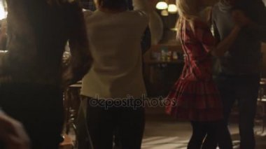 İnsanlar iyi bir zaman birlikte bir çubuk yaparken dans ediyor.