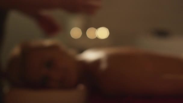 Atrakcyjna młoda kobieta fit jest posiadanie gabinetem masażu w romantycznej atmosferze Spa. — Wideo stockowe