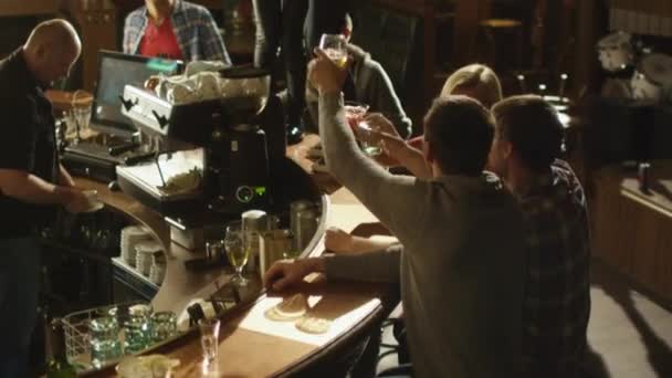 Deux filles dansent avec des boissons sur une table pendant que tout le monde passe un bon moment ensemble dans un bar . — Video