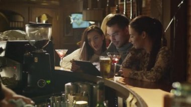 Arkadaşlar gülmek, iyi bir zaman birlikte bir çubuk yaparken tablet bilgisayar kullanın.