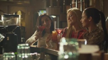 Kız gülmek, tezahürat ve içki kokteyl sırasında bir barda birlikte iyi vakit geçiriyor.