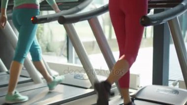 Pembe elbise spor salonunda koşu bandı üzerinde çalışan çekici beyaz kız.