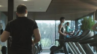 Uygun atletik erkek kulaklık ile spor salonunda treadmill üzerinde çalıştırmak başlıyor.
