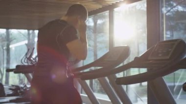 Uygun atletik erkek kulaklık ile spor salonunda treadmill üzerinde çalıştırmak başlıyor.