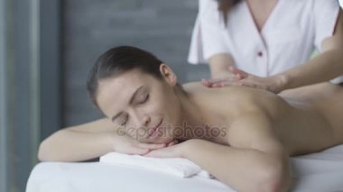 Güzel kadın sağlık merkezinde bir kadın masör rahatlatıcı bir masaj almak.