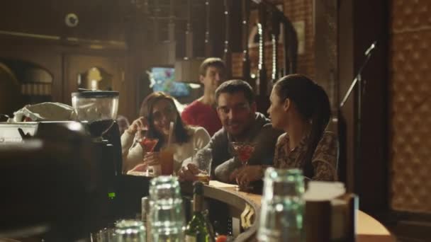 Друзі сміються, п'ють пиво і коктейлі, проводячи час разом у барі . — стокове відео