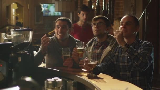 Друзі дивляться спортивну гру в барі і вітають з рахунком . — стокове відео