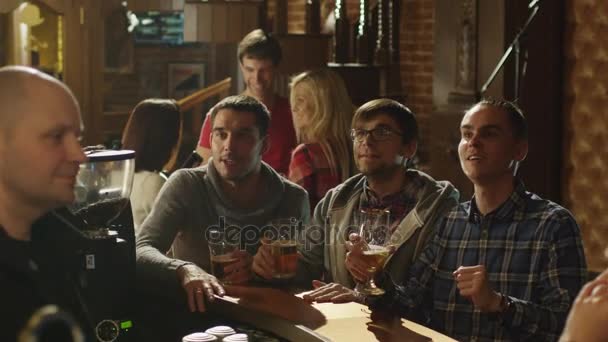 Amigos están viendo un partido de deportes en un bar y animando a una puntuación . — Vídeo de stock