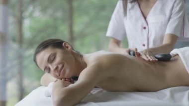Genç esmer kadın rahatlatıcı bir taş masaj Sağlık Merkezi oluyor.