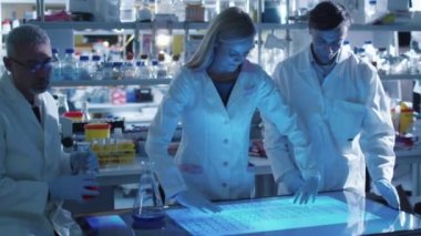 Bilim adamlarının ekip bir laboratuvar dijital dokunmatik ekran üzerinde çalışıyoruz.